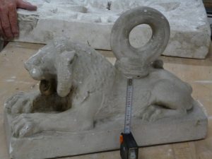 Petit lion accroupi avec anneau sur le dos